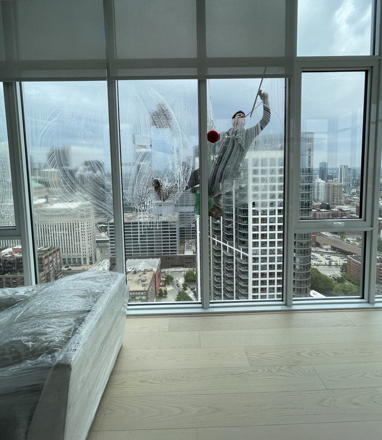 Skyscraper window cleaner washing high rise apartment