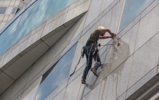 Rope access technician performing high-rise window cleaning on a commercial building in St. Louis, MO