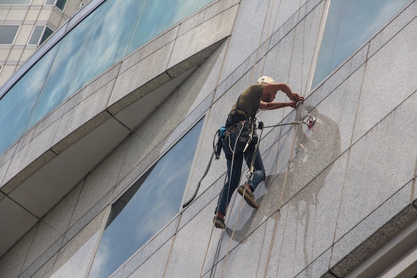 Rope access technician performing high-rise window cleaning on a commercial building in St. Louis, MO