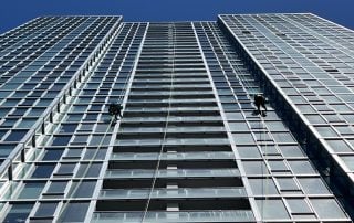 Technicians performing high rise building window cleaning on a Chicago skyscraper facade