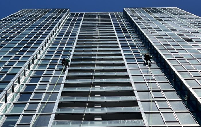 Technicians performing high rise building window cleaning on a Chicago skyscraper facade
