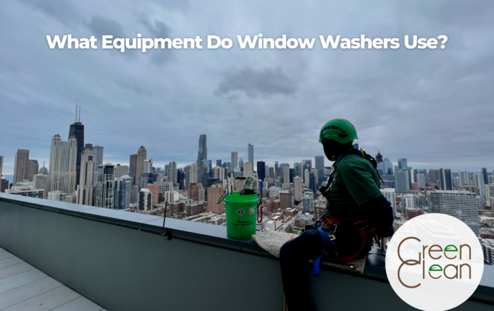 Window washer in full safety gear looking at Chicago's city view.