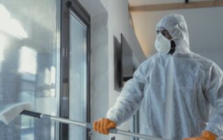 Professional commercial window cleaner in protective gear performing fall window cleaning maintenance for Chicago business property.