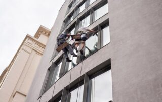 Technician performing high-rise window cleaning using rope access on a building exterior in Chicago.