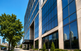 Clean commercial office building exterior in Kansas City, MO showcasing professionally maintained glass windows and facade during summer conditions.